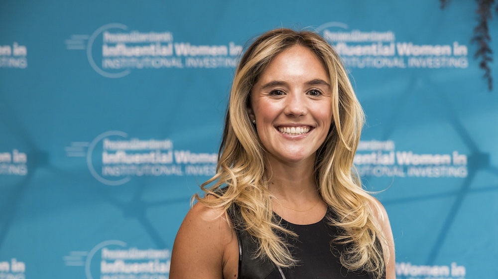 Professional headshot of a smiling woman with blonde hair against a blue branded backdrop Professional headshot of a smiling woman with blonde hair against a blue branded backdrop
